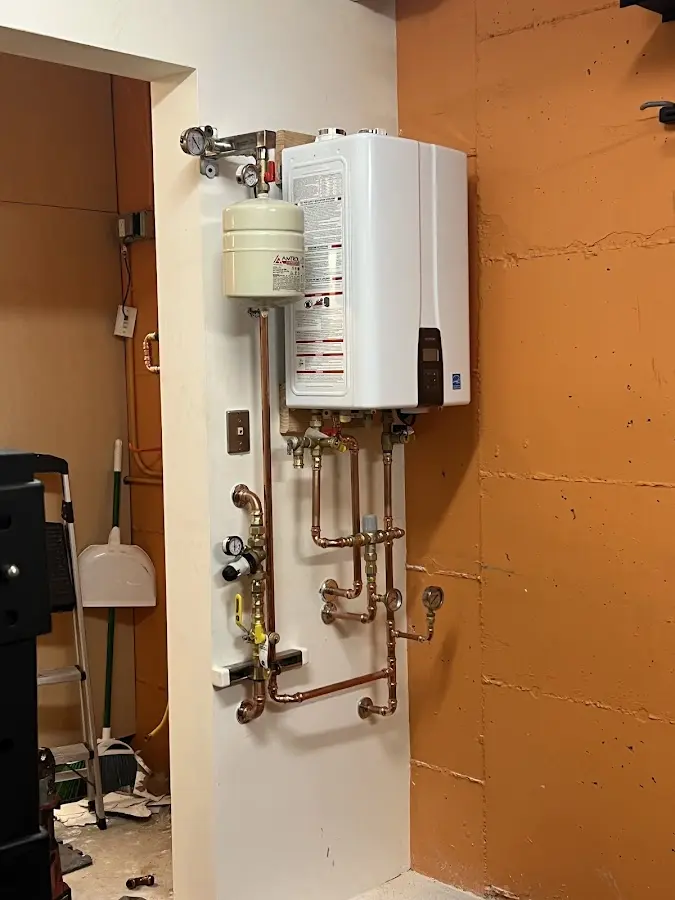 Plumbing technician inspecting water heater connections in Gladewater